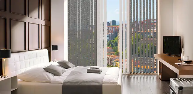 Moderne Vertikaljalousien am großen Schlafzimmerfenster mit Blick auf die Stadt