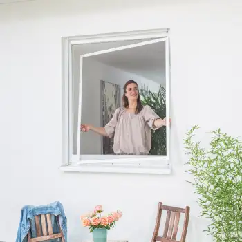 Frau setzt einen Fliegengitter Spannrahmen in ein geffnetes Fenster ein